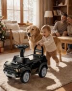 Toddler pushing a First Ride On black Ford Bronco Raptor toy car in a home setting with family and pet